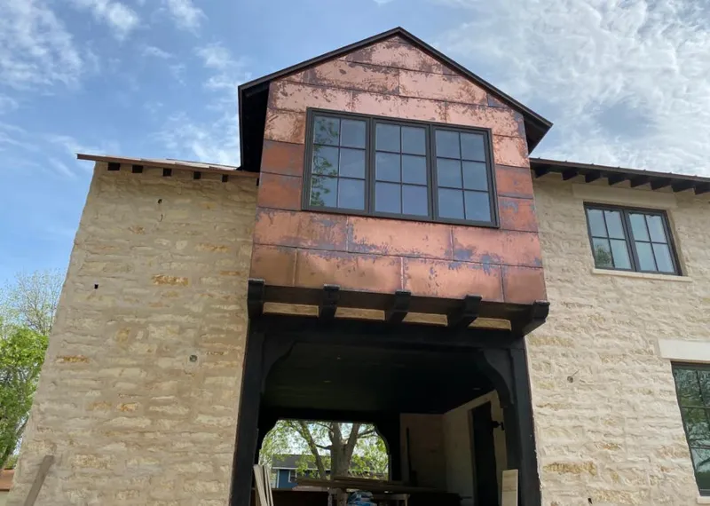 Copper metal panel facade on a stone building for Roof Repair in Patterson